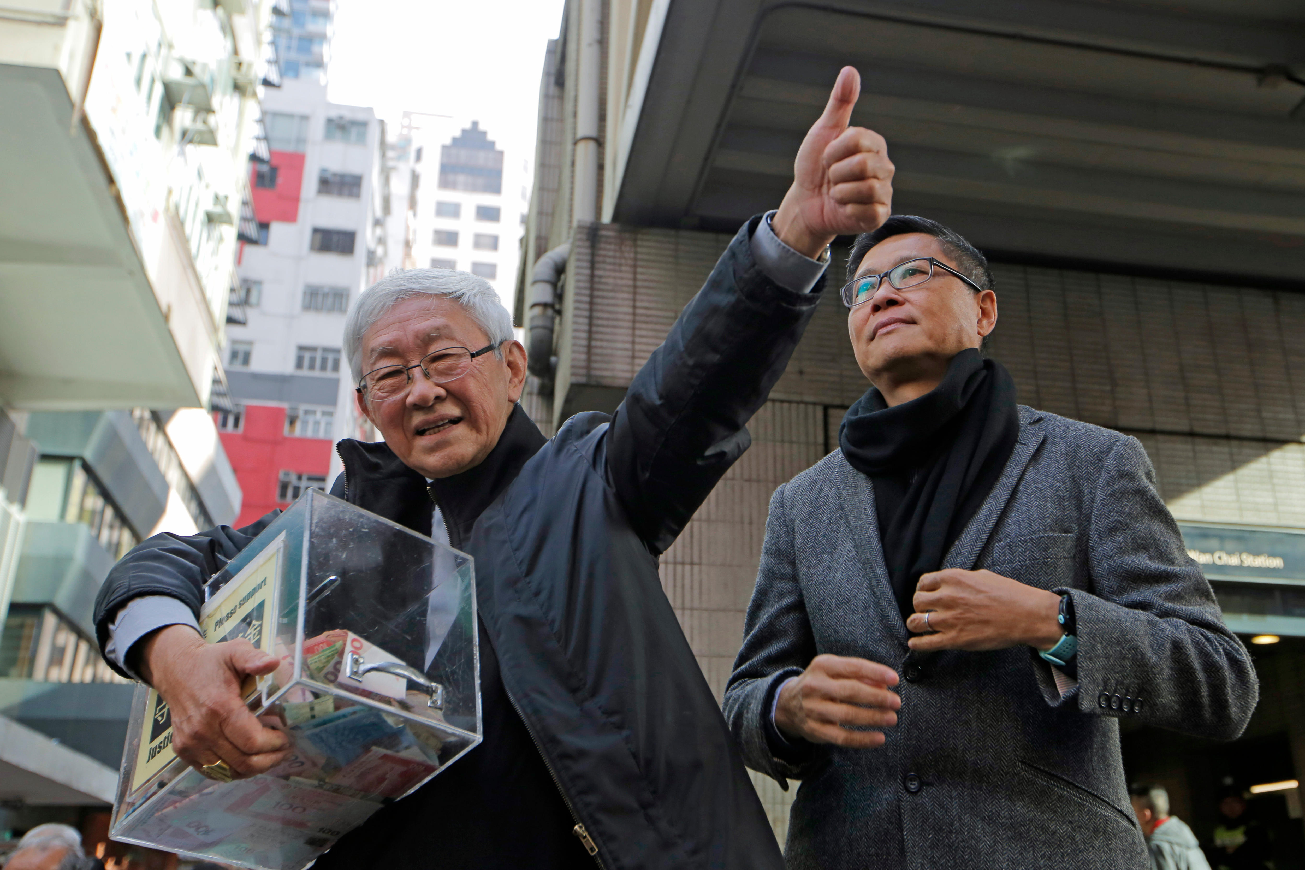 Retired archbishop of Hong Kong Cardinal Joseph Zen holds a donation box.